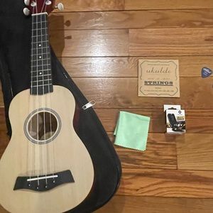 Ukulele with case, 2 picks, strings, tuner, and cleaning rag